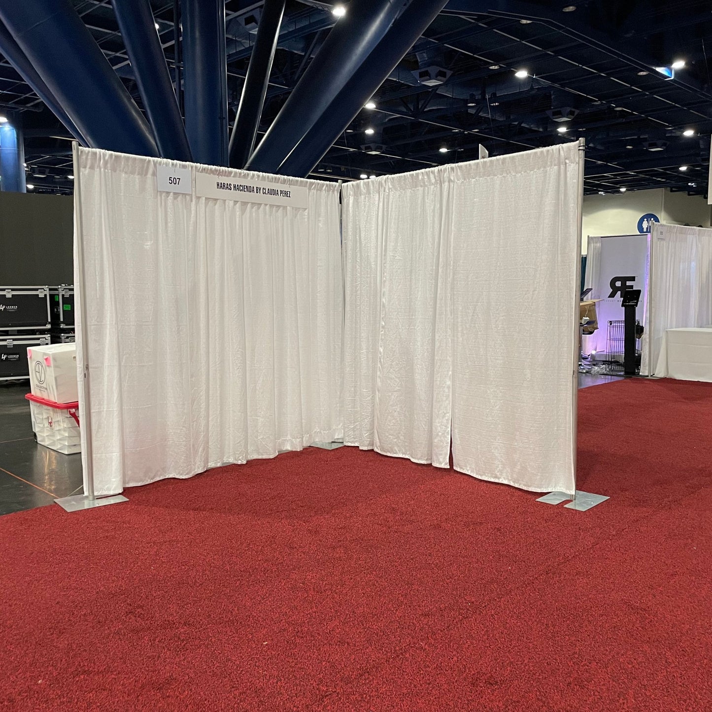 8'x8' corner trade show booth sitting on red carpet with white drape