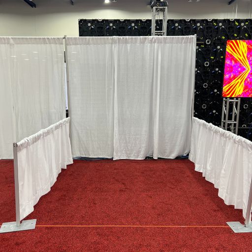 8'x8' aisle trade show booth sitting on red carpet. Left and right sides have 4' short walls. 