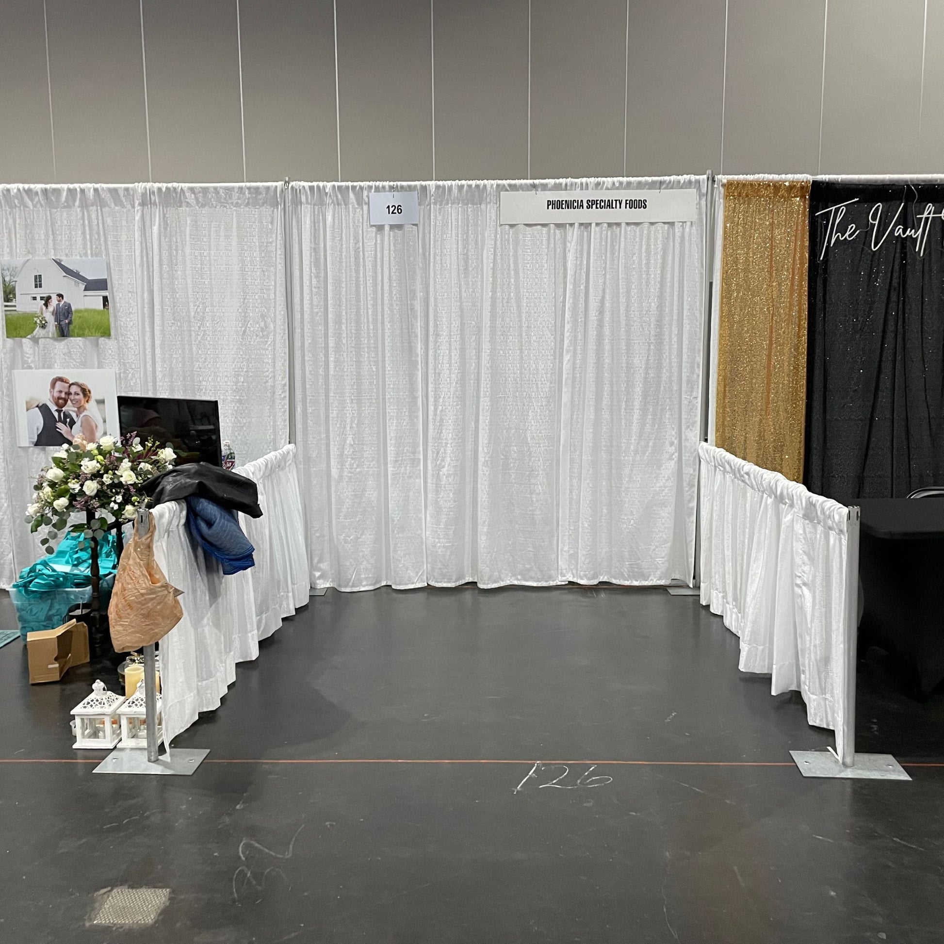 8'x8' aisle trade show booth sitting on concrete. Left and right sides have 4' short walls. 